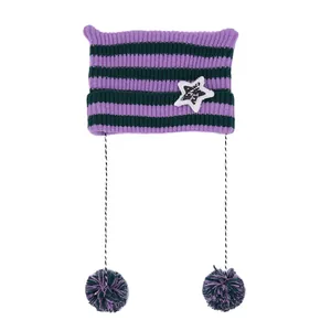 Dettaglio di un cappello in maglia a righe viola e verdi con orecchie di gatto e pompon