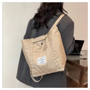 Detalle de la bolsa tote grande de nailon con etiqueta de moda y correa para uso diario