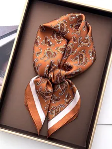 Detailed macro view of the bronze paisley pattern silk scarf with elegant white borders
