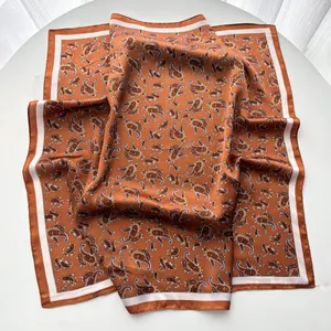 Detail of soft faux silk paisley pattern scarf with elegant white contrast border