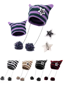 Dettaglio del cappello a maglia a righe con orecchie di gatto, pompon e clip a stella