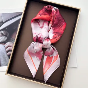 Floral silk scarf with red and pink flower print elegantly folded in a luxury gift box