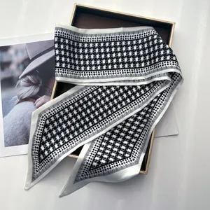 Detail of elegant black and white houndstooth silk scarf on a premium gift box