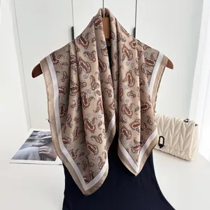 Detail of vintage paisley silk square scarf in khaki with elegant border on hanger