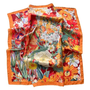 Elegant floral silk square scarf in red and orange tones with vibrant botanical patterns