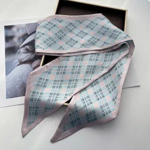 Detail of silk-like scarf featuring pink and blue plaid pattern with pointed ends