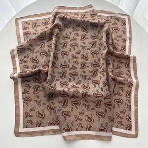 Macro detail of paisley pattern on silk-like scarf with elegant earth tone borders
