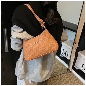 Detailed view of caramel brown textured shoulder bag with chic knotted strap and metal buckle