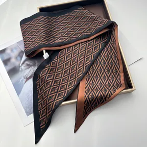 Detailed view of luxury geometric print silk twilly scarf displayed in a gift box
