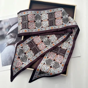 Close-up of elegant silk twilly with geometric tree patterns on a gold display box