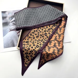 Detail of silk-like twilly scarf with leopard print and checkerboard pattern in a gift box