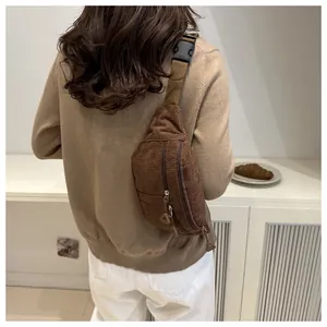 Detailed view of the dark brown corduroy chest bag texture with adjustable strap and buckles