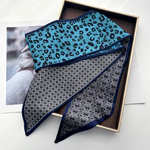 Detail of silk-like scarf with leopard print, checkered patterns, and geometric textures