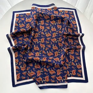 Detail of navy blue square silk scarf with red paisley patterns and cream white borders