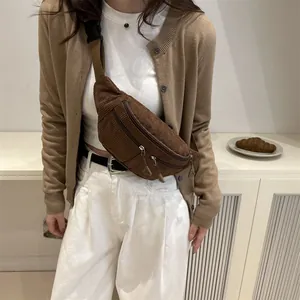 Brown corduroy crossbody chest bag with adjustable strap worn by a model in casual style