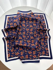Detail of silk-like square scarf featuring vintage blue paisley pattern on a white pedestal