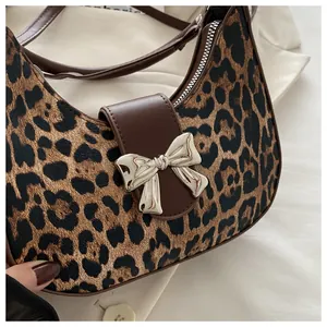 Dettaglio borsa leopardata con fibbia a fiocco argento e rifiniture in pelle marrone