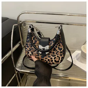 Dettaglio della borsa hobo leopardata con fiocco metallico e manico rotondo