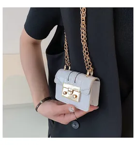 Close-up of white crocodile pattern mini crossbody bag with gold chain and square buckle
