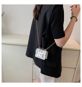 Close-up of white crocodile pattern mini bag with gold chain strap and square metal buckle