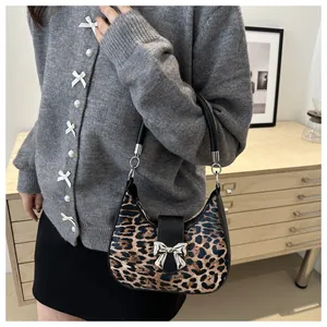 Dettaglio della borsa hobo leopardata con fibbia a fiocco in argento e tracolla in pelle