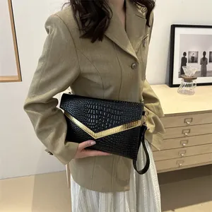 Fashionable black crocodile embossed envelope clutch bag with gold V-shape metal trim