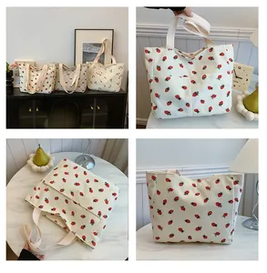 Detail view of large corduroy tote bag featuring strawberry and cherry print patterns