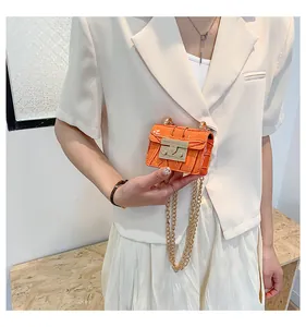 Detailed view of orange crocodile texture mini bag with elegant gold chain strap
