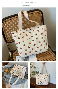 Detail of cream corduroy tote bag with strawberry print and large front pocket