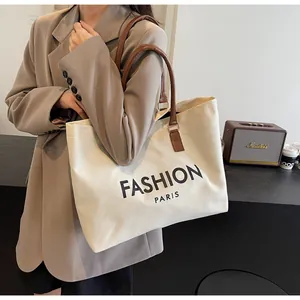 Detalle del bolso tote de lona con asas de cuero marrón y estampado Fashion Paris