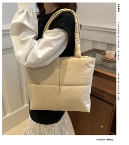 Quilted nylon tote bag in cream showing the plush texture and cross-stitch pattern