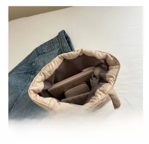 Interior view of beige quilted tote bag showing laptop, phone and umbrella capacity