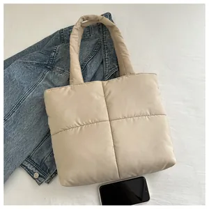 Close-up of beige quilted nylon tote bag with soft padded texture and square pattern