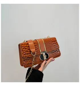 Detail shot of vintage brown crocodile embossed leather bag with gold metal clasp lock