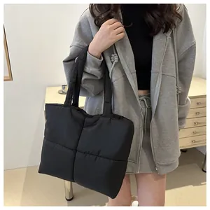 Close-up of black quilted puffer tote bag made of high-quality nylon with square stitching