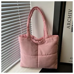 Detail of pink quilted nylon tote bag showing soft puffy texture and square stitching