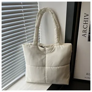Close-up of soft quilted texture and sturdy handles on the white nylon down tote bag