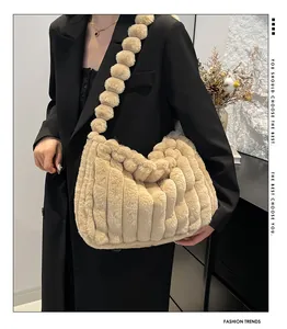 Close-up of beige plush tote bag featuring faux fur striped texture and pom-pom strap