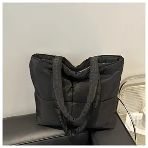 Detail view of black quilted puffer tote bag with spacious nylon shoulder straps