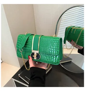 Macro shot of green crocodile-embossed leather finish and gold-tone twist lock closure