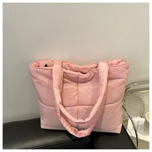 Detail of pink quilted nylon tote bag with soft padded texture and square pattern