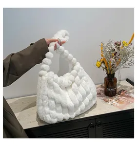 Detailed view of white plush handbag featuring unique pom-pom texture and soft knotted handle