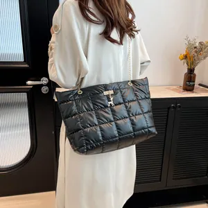 Quilted black puffer tote bag with gold deer charm and chain strap shown in a modern interior