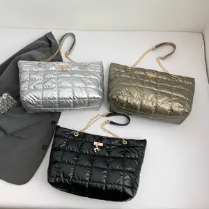 Quilted puffer tote bags in silver, gold, and black with deer pendant and chain straps