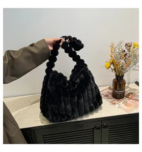 Close-up of fluffy black faux fur tote bag with a unique twisted handle and striped texture