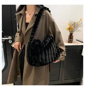Detail of black plush tote bag with striped texture worn with a stylish trench coat