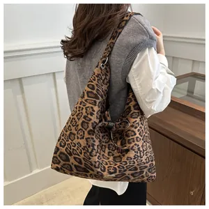 Dettaglio della borsa tote scamosciata leopardata con fiocco e logo in metallo
