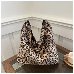 Dettaglio della borsa tote leopardata con tracolle in pelle marrone e anelli in metallo