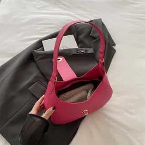 Magenta faux leather baguette bag with golden buckle and sleek shoulder strap design