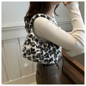 Detail of leopard print plush tote bag on a model featuring soft faux fur texture